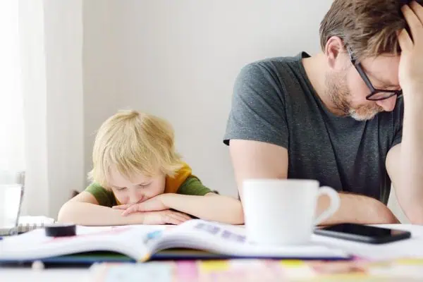 Frustrated father and child sitting at a cluttered table—highlighting how ADHD can affect both parenting and learning. Strategic Hypnotherapy from Mindshift Mentors offers support for emotional regulation and family balance.
