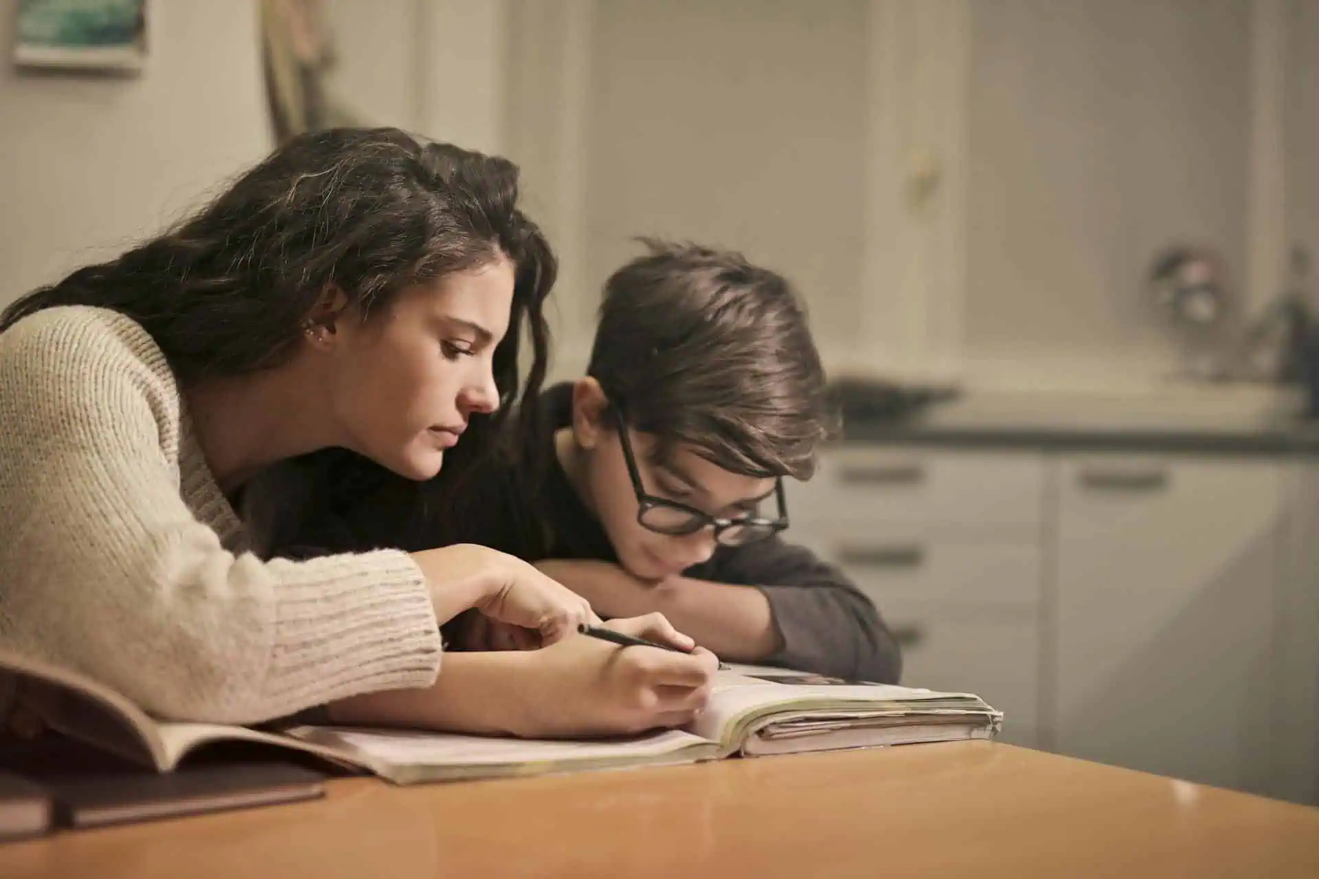 Mother helping her child with homework at the table, showing support and focus as part of an ADHD-friendly homework routine.
