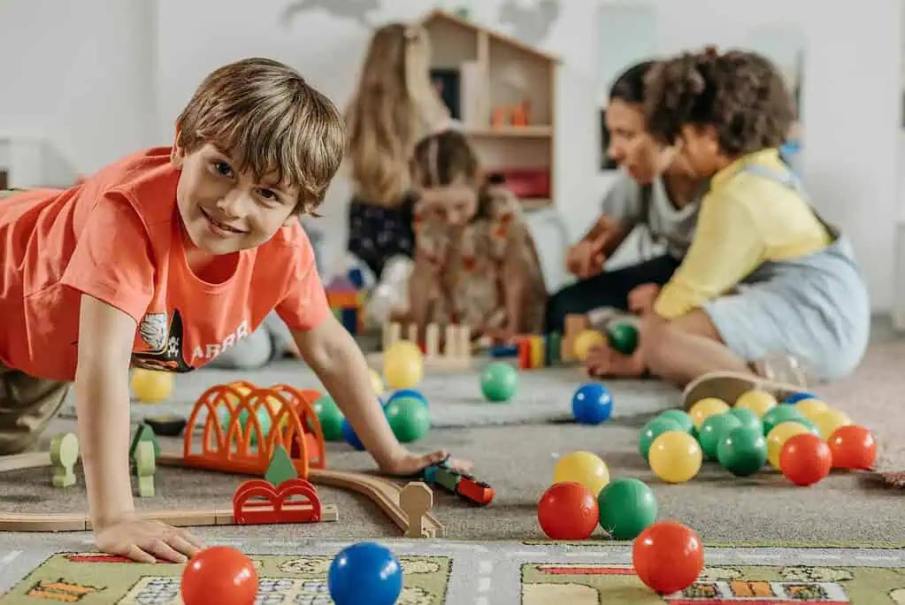 Children playing with colorful balls and toys in a classroom, using playtime to release energy after school