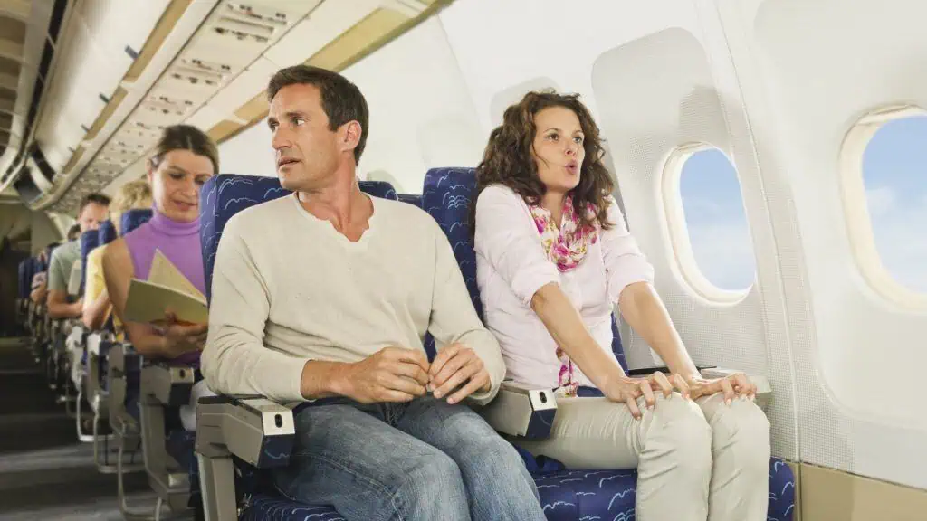 Nervous airline passengers showing signs of fear and anxiety during a flight