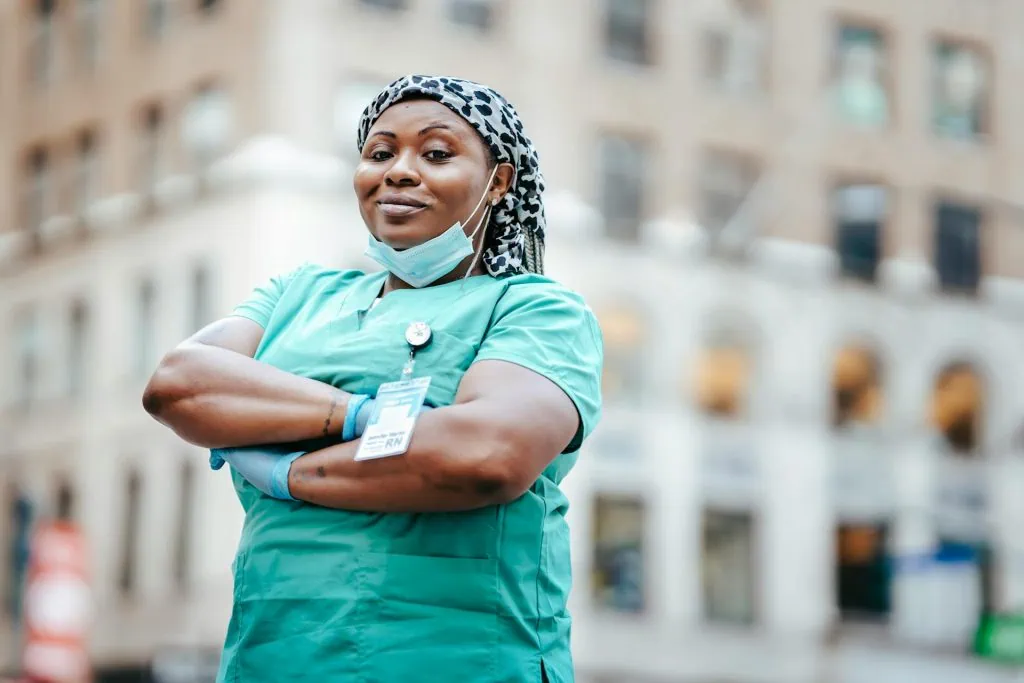 Confident female frontline nurse standing outdoors in uniform, representing women in male-dominated emergency services