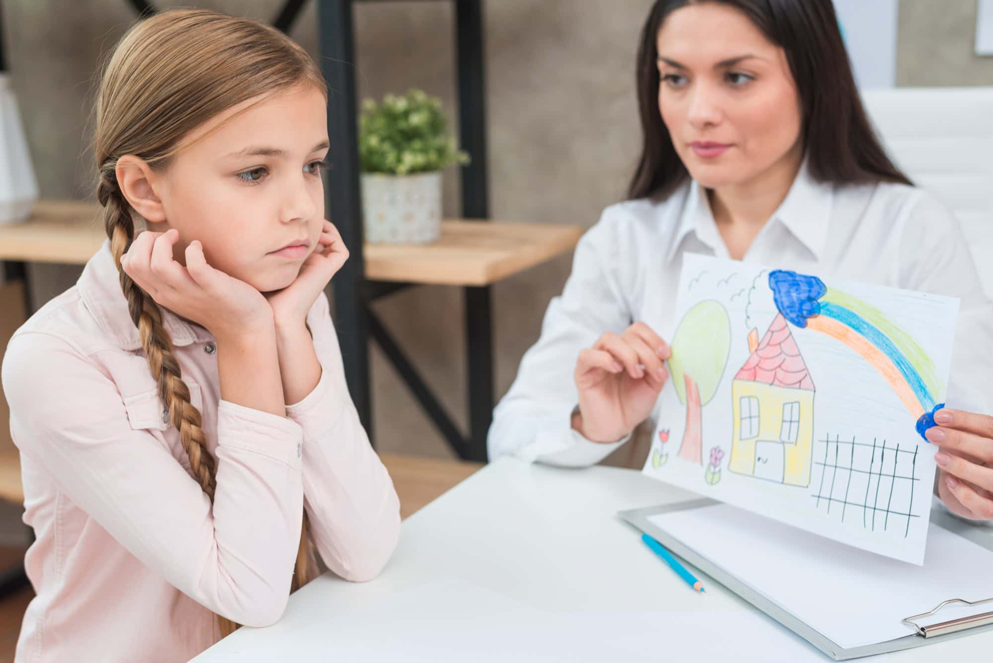 A child in a therapy session showing a drawing, illustrating challenges linked to Dyspraxia vs DCD vs ADHD.