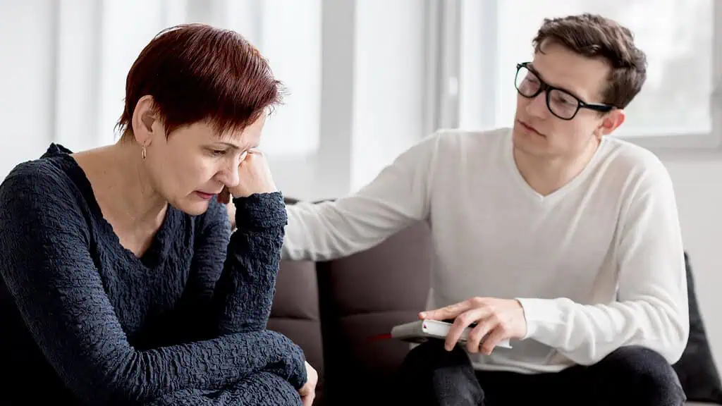 Therapist offering support to a distressed woman during a counseling session, reflecting the importance of professional help for adults with dyspraxia.
