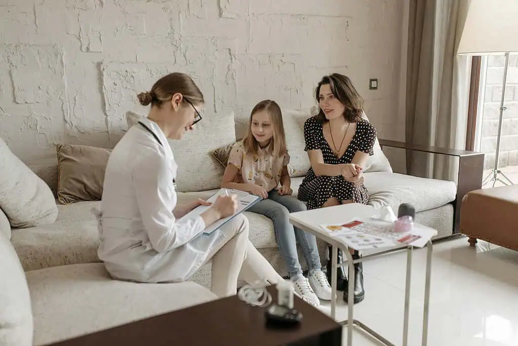 Mother and child consulting a healthcare professional, discussing support options for children with dyspraxia.