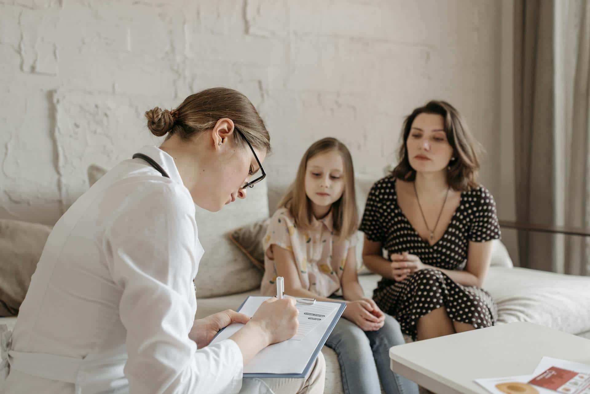 Therapist conducting a hypnotherapy for ADHD kids consultation with a mother and daughter in a calm, supportive setting.