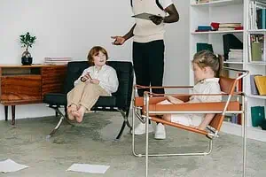 Therapist leading a hypnotherapy for ADHD kids session with two children in a modern, comfortable office setting.