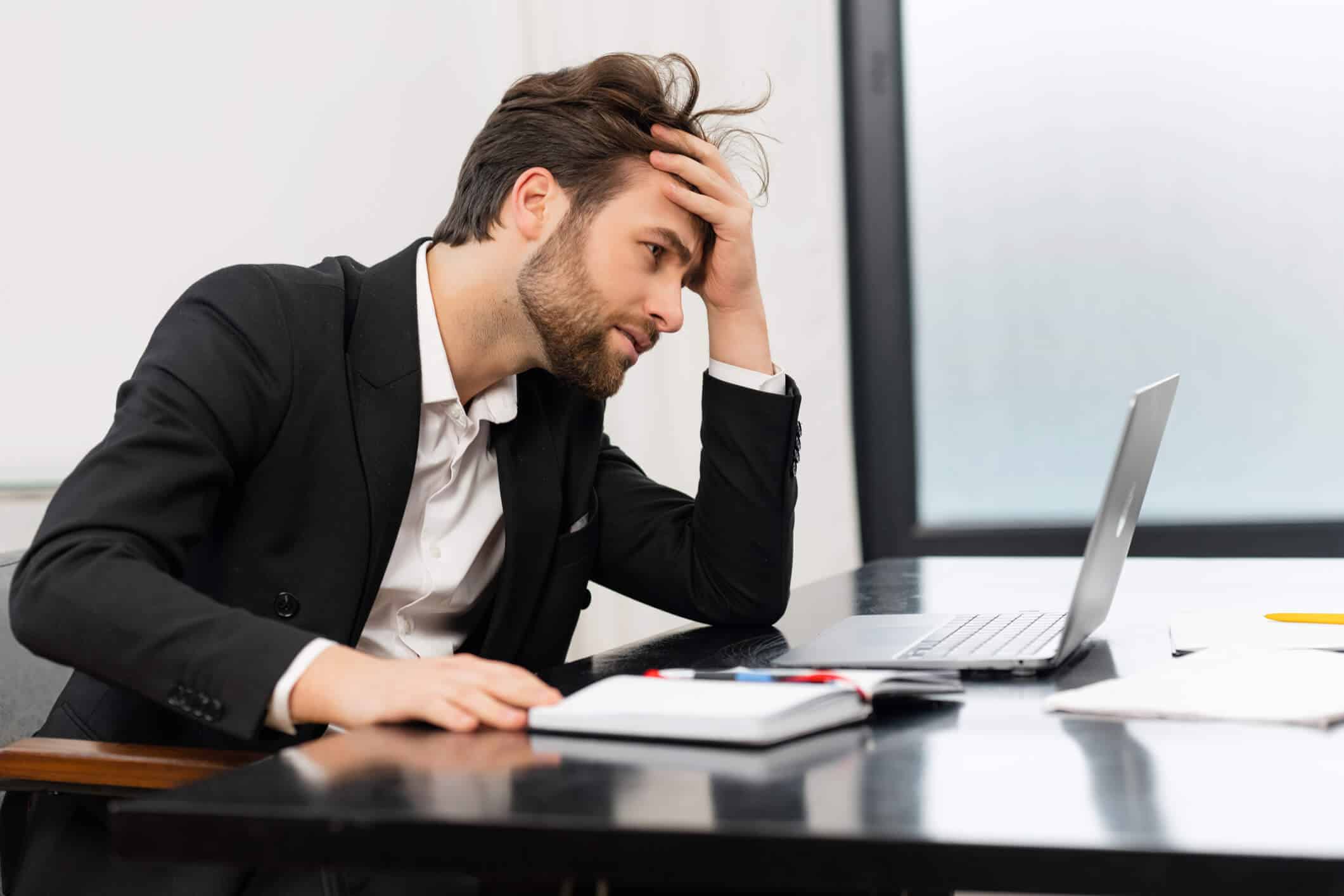 Man in suit stressed at desk