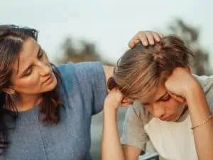 Concerned mother comforting her stressed teenage son during an emotional moment