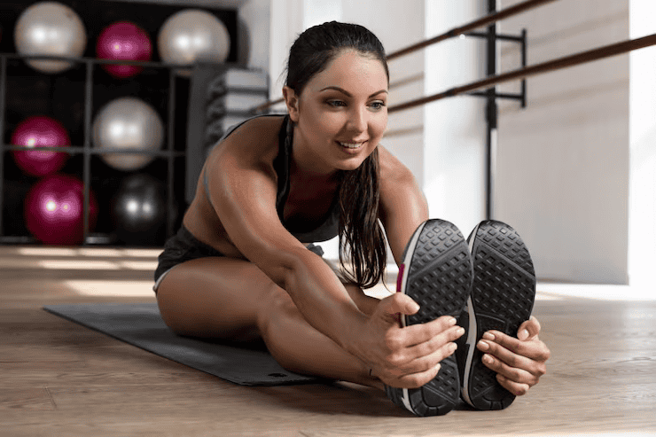 Photo beautiful female stretching floor sitting mat sport gym