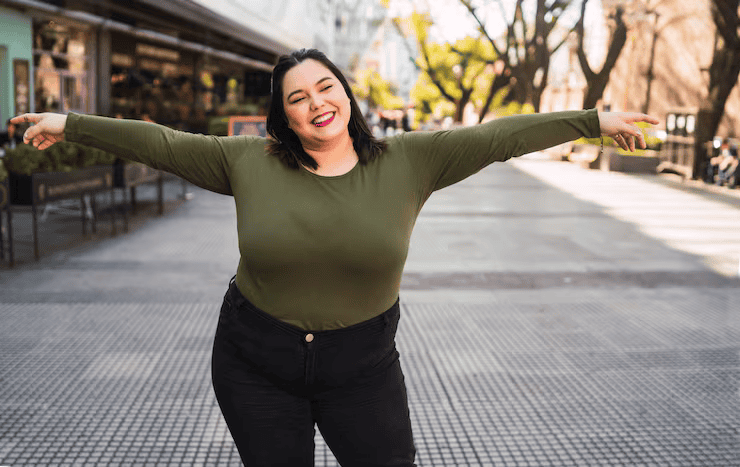 Portrait young plus size woman smiling while standing outdoors street urban concept