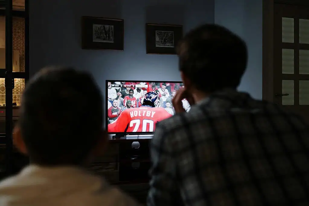 Child and adult watching TV together, illustrating the impact of screens and ADHD on attention and daily routines.