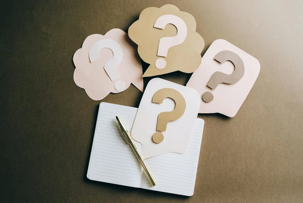 Notebook and pen with question mark cutouts, symbolizing sleep disorder solutions.
