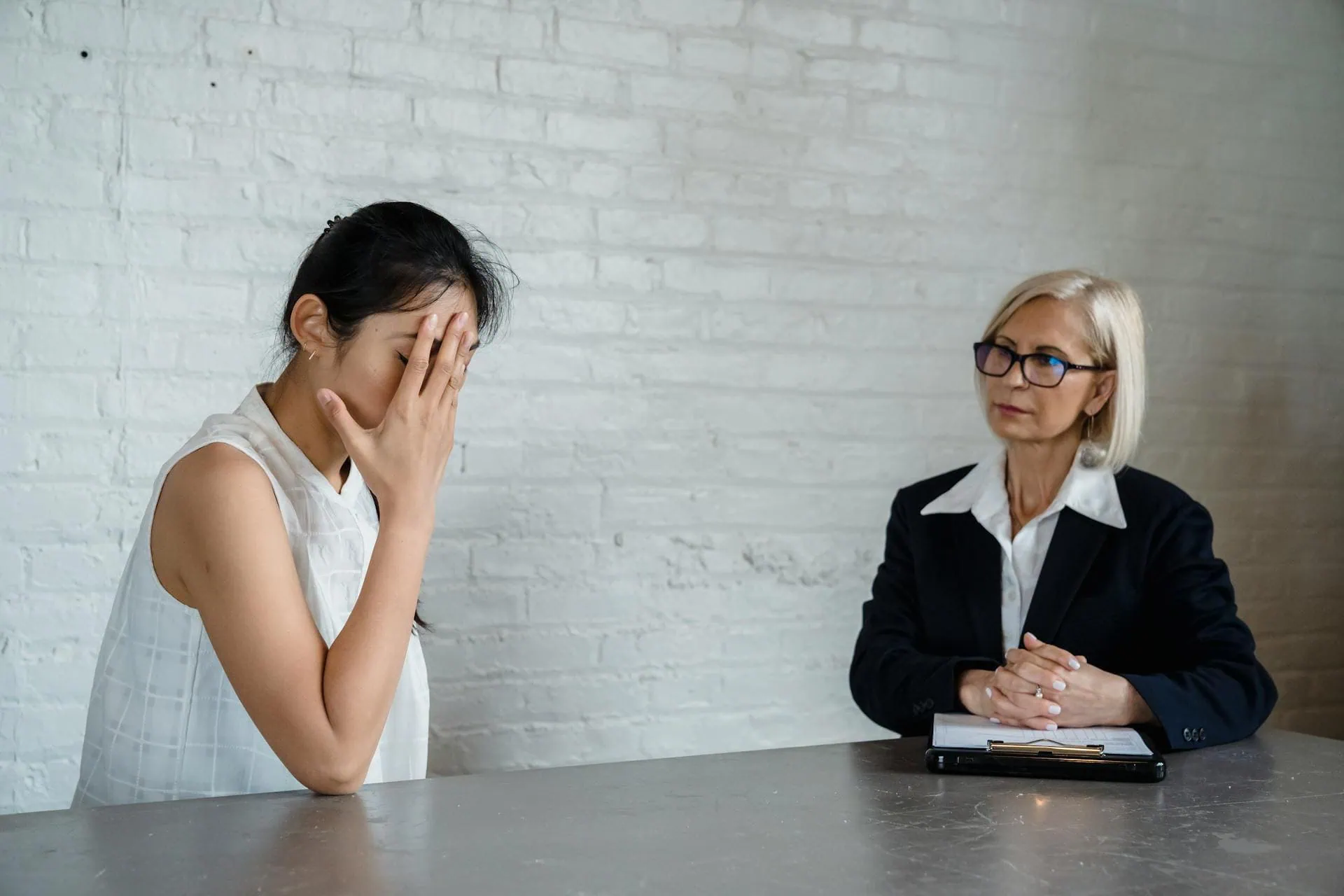 Young woman stressed and covering face during therapy session with a counselor, discussing emotional issues Sleep Insomnia Blog Post