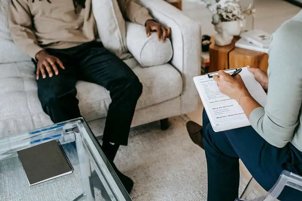 A therapist taking notes during a consultation session, representing professional support and management strategies for Developmental Coordination Disorder (DCD).