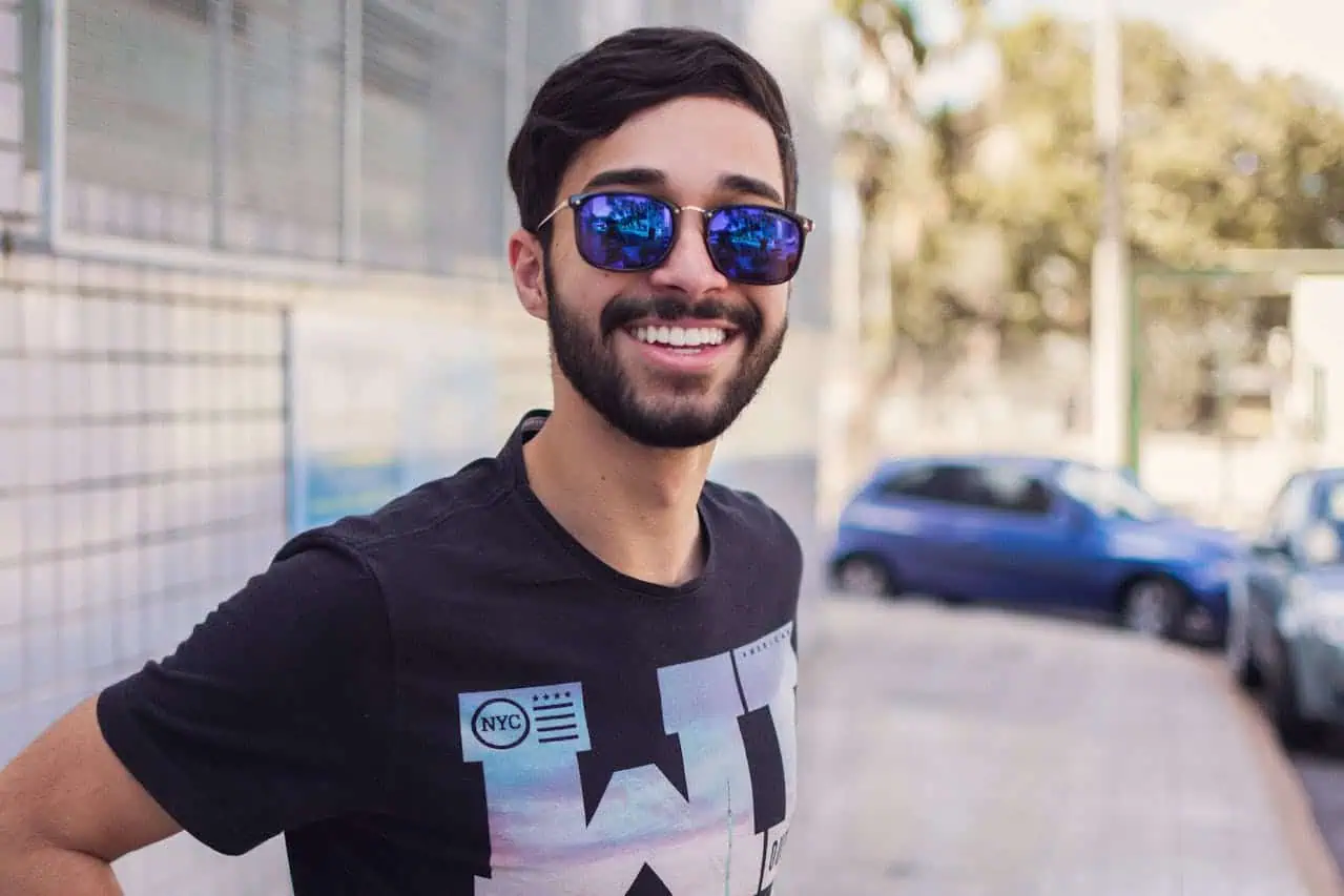 Young man smiling in sunglasses outdoors—representing the freedom and comfort gained after overcoming TMJ-related discomfort.