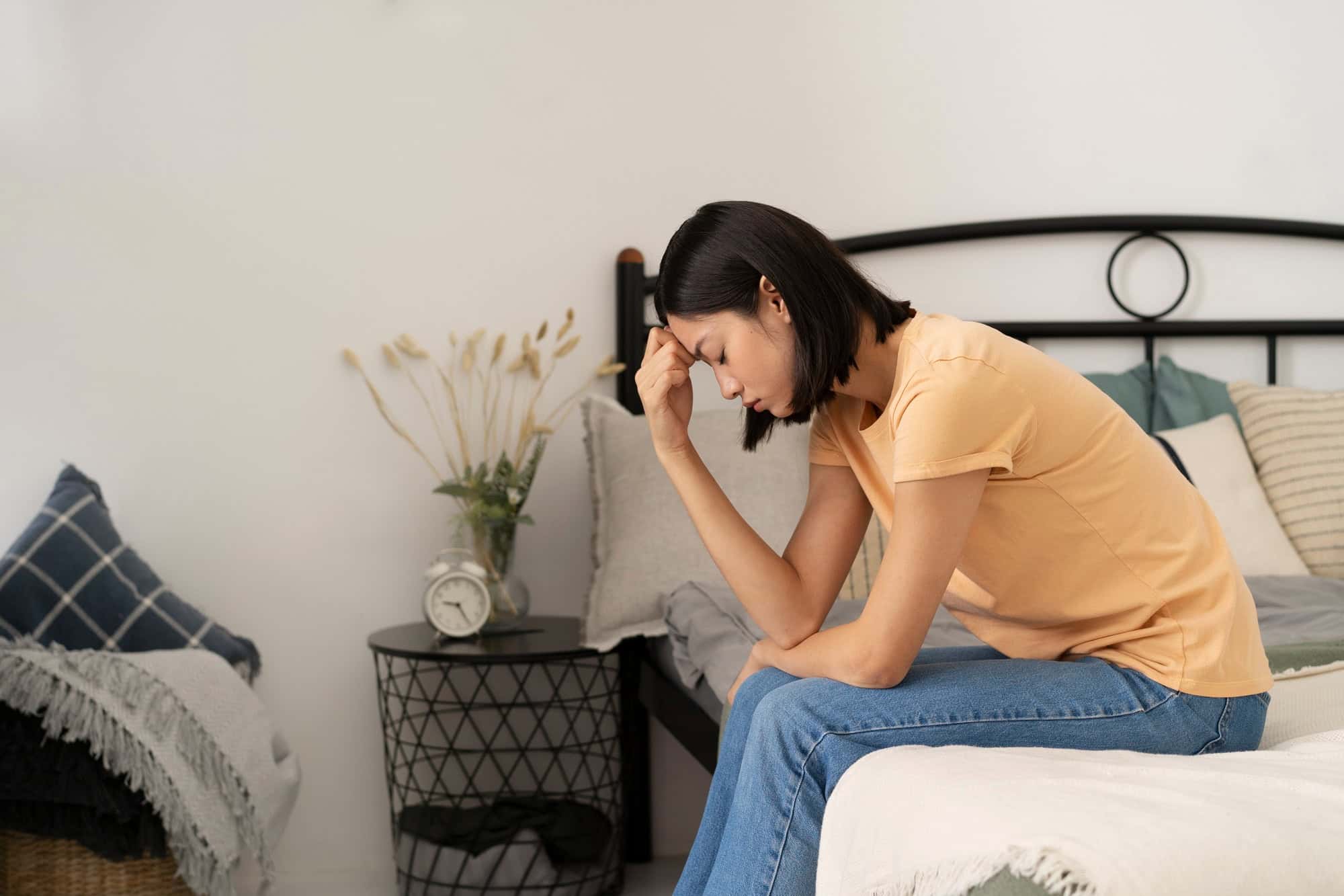 Woman sitting on the edge of the bed after a stressful day