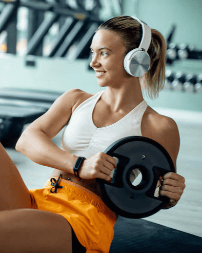 Young sportswoman having cross training with weight plate gym